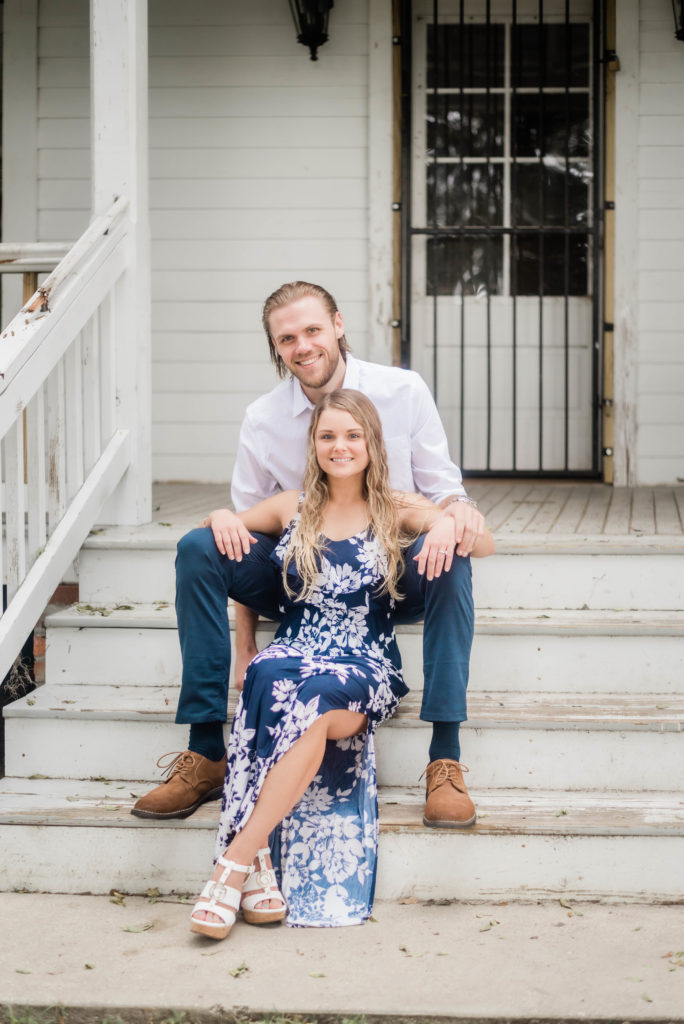 couple sitting on the steps of the e Bennett House,  Alpine Groves Park for engagement photos Photo By Black Tie & Co. www.btcweddings.com