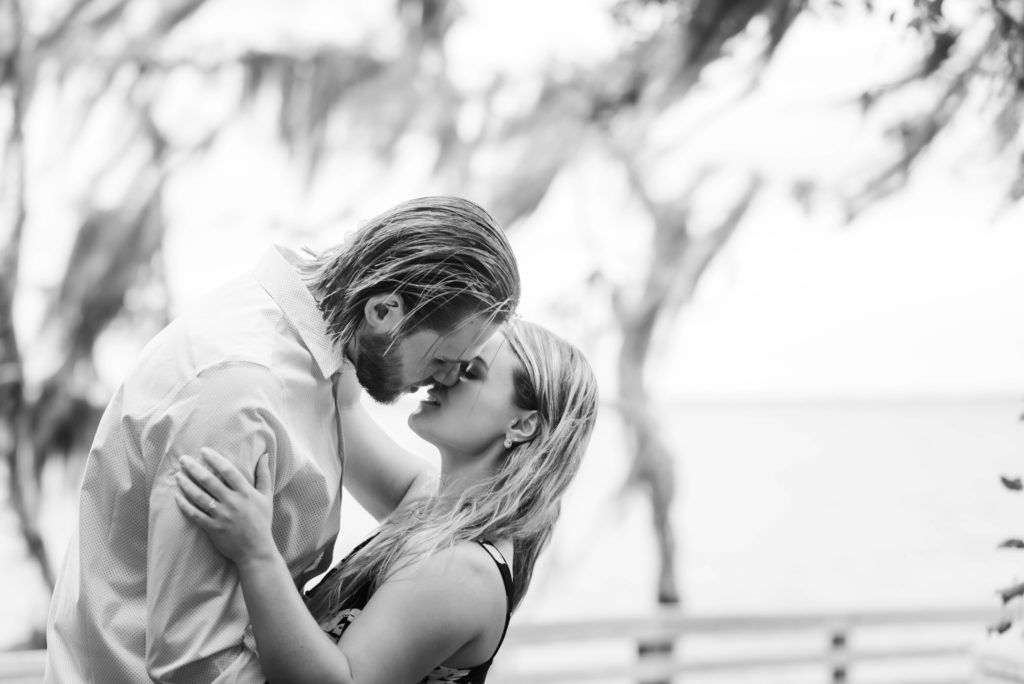 couple about to kiss during engagement photo the dock of the St Johns River at the   Alpine Groves Park. in Jacksonville Florida  Photo By Black Tie & Co. www.btcweddings.com