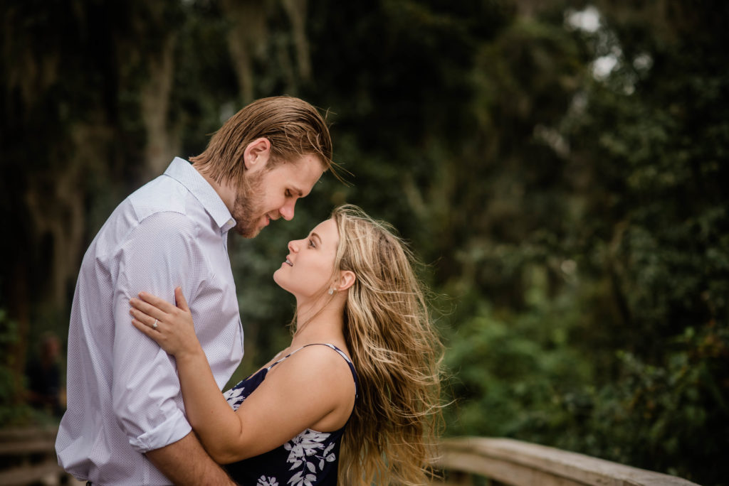 couple looking at each other lovingly engagement photo the dock of the St Johns River at the   Alpine Groves Park. in Jacksonville Florida  Photo By Black Tie & Co. www.btcweddings.com