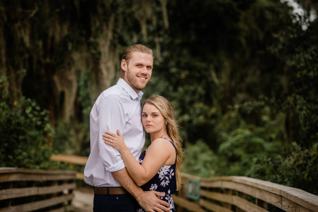 couple taking engagement photo the dock of the St Johns River at the   Alpine Groves Park. in Jacksonville Florida  Photo By Black Tie & Co. www.btcweddings.com